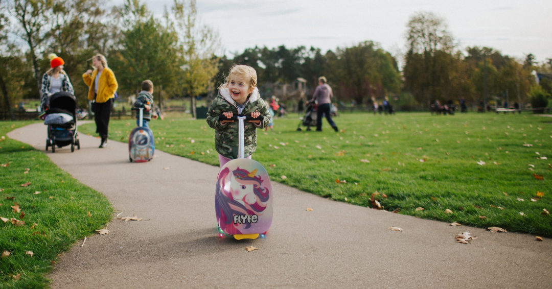 Little girl using her Flyte Luna the Unicorn Scootcase outside.