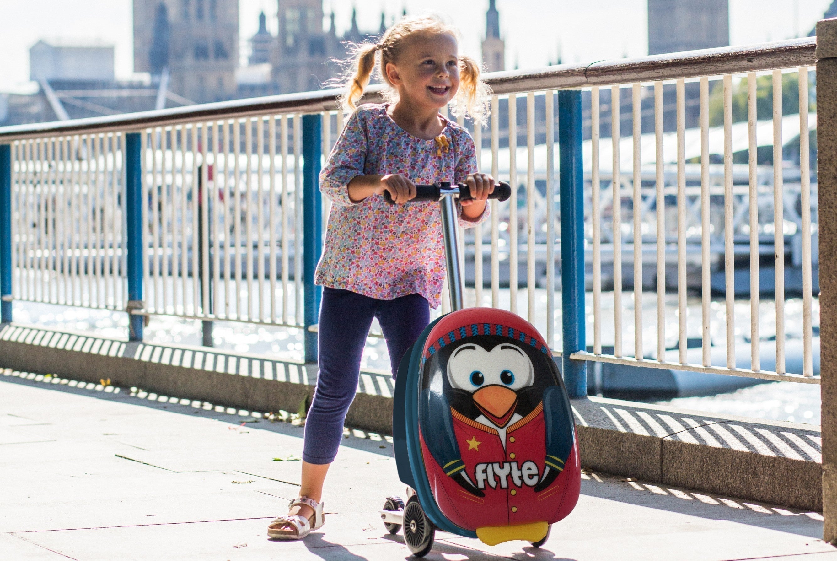 Girl smiling with her Flyte scootcase in London.