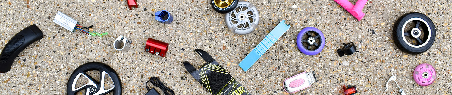 Spare scooter parts including wheels, brake parts and bolts.