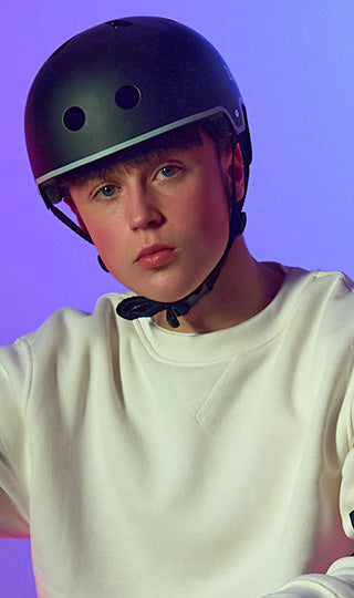 Close up pof teenage boy in a black Zinc scooter helmet.