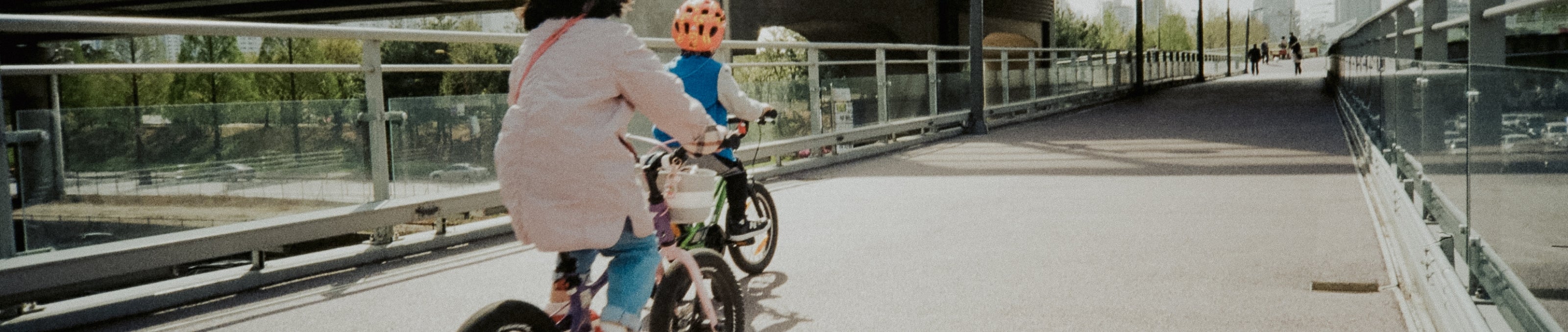 An adult and child riding their bikes in an outside setting.