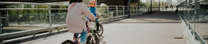 An adult and child riding their bikes in an outside setting.