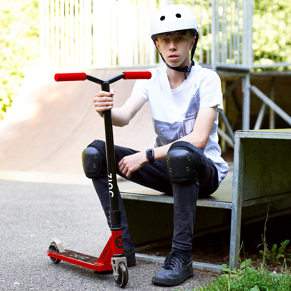 Zinc Stunt scooter in Red and Black. Being used by boy in Zinc protective gear.