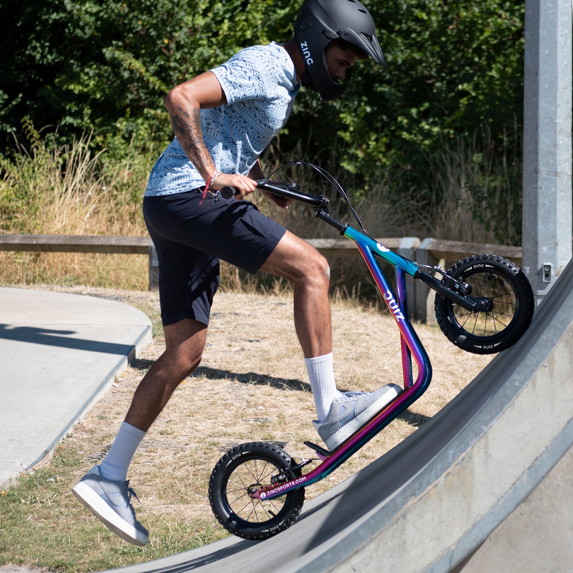 Boy performing on Zinc 12 Inch BMX Scooter at Skate Park - Action Sports Fun