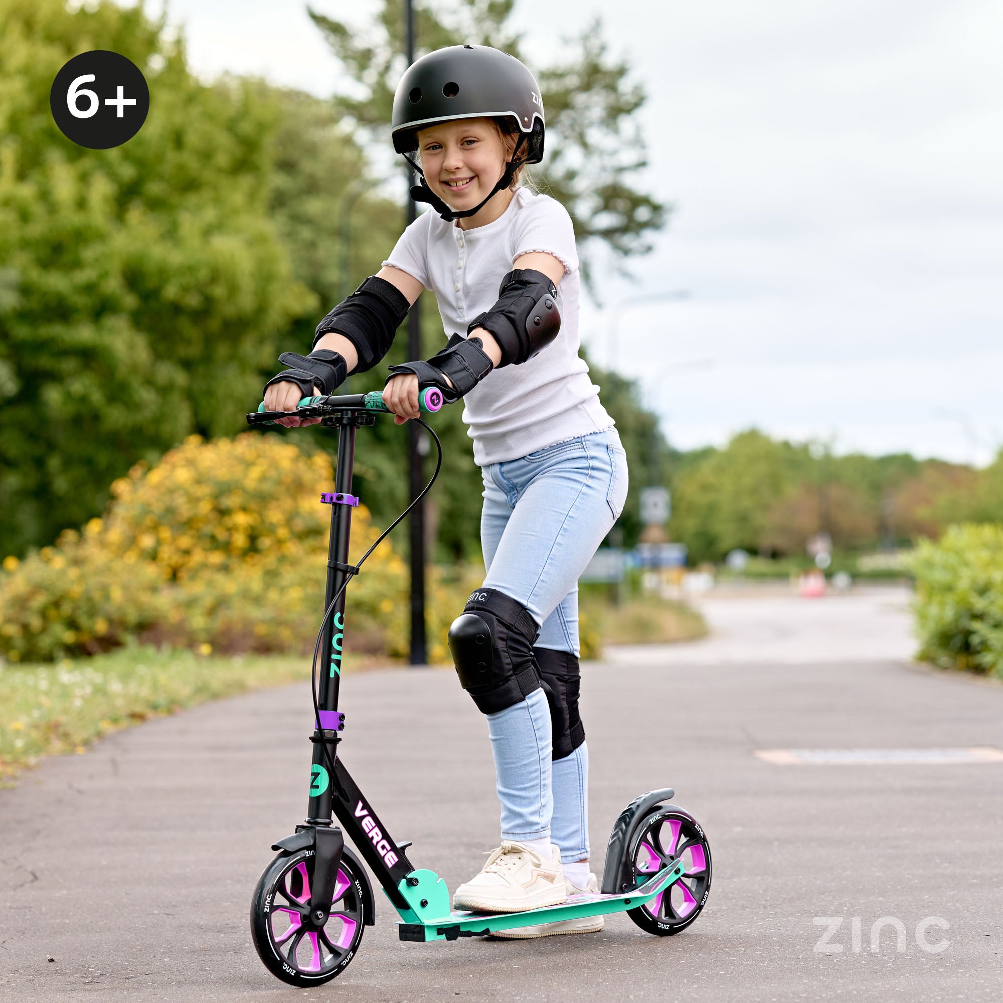 Child riding a scooter with protective gear in an outdoor setting, featuring the brand 'Zinc'.