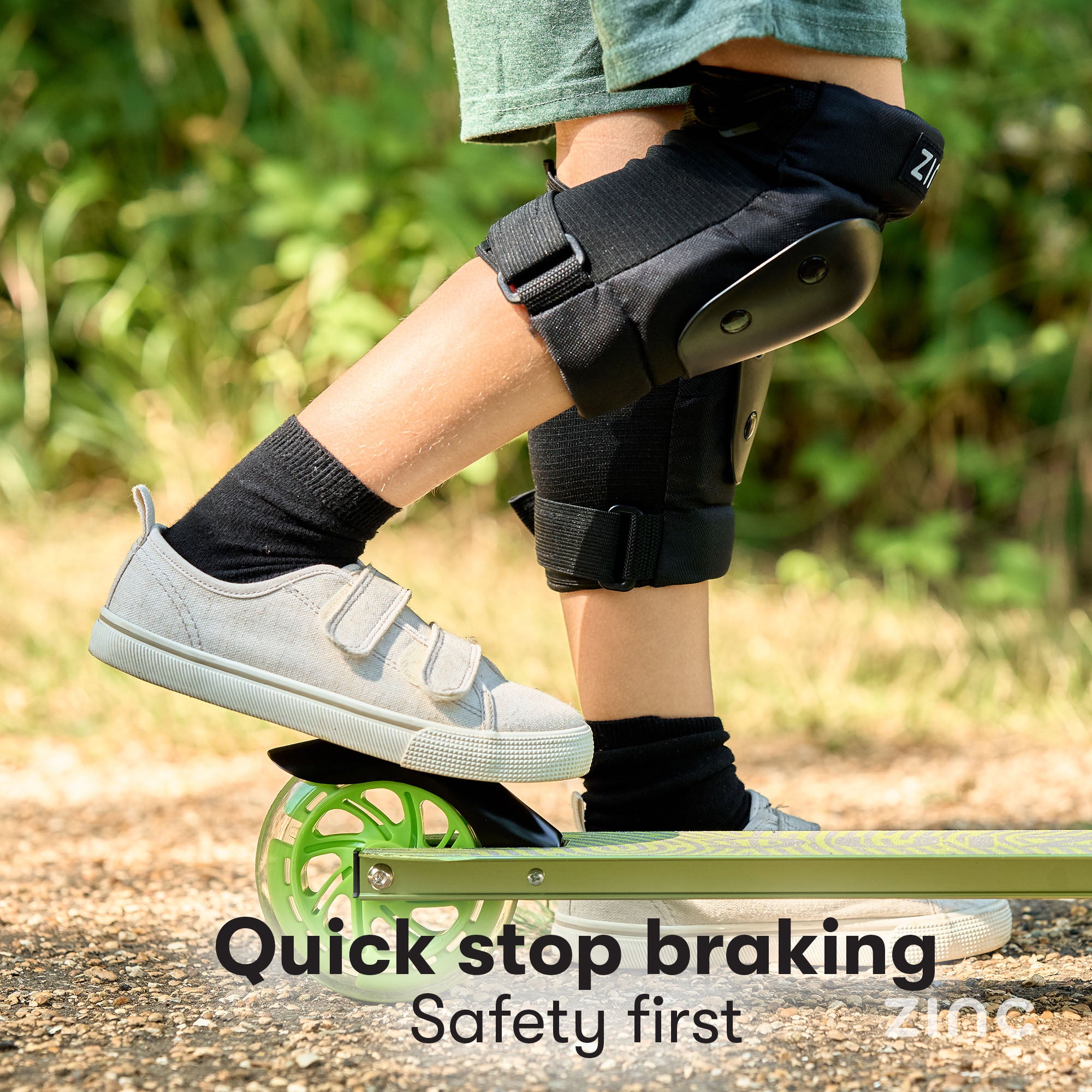 Child using rear footbrake on Zinc Identity scooter demonstrating quick stop braking for safe riding control