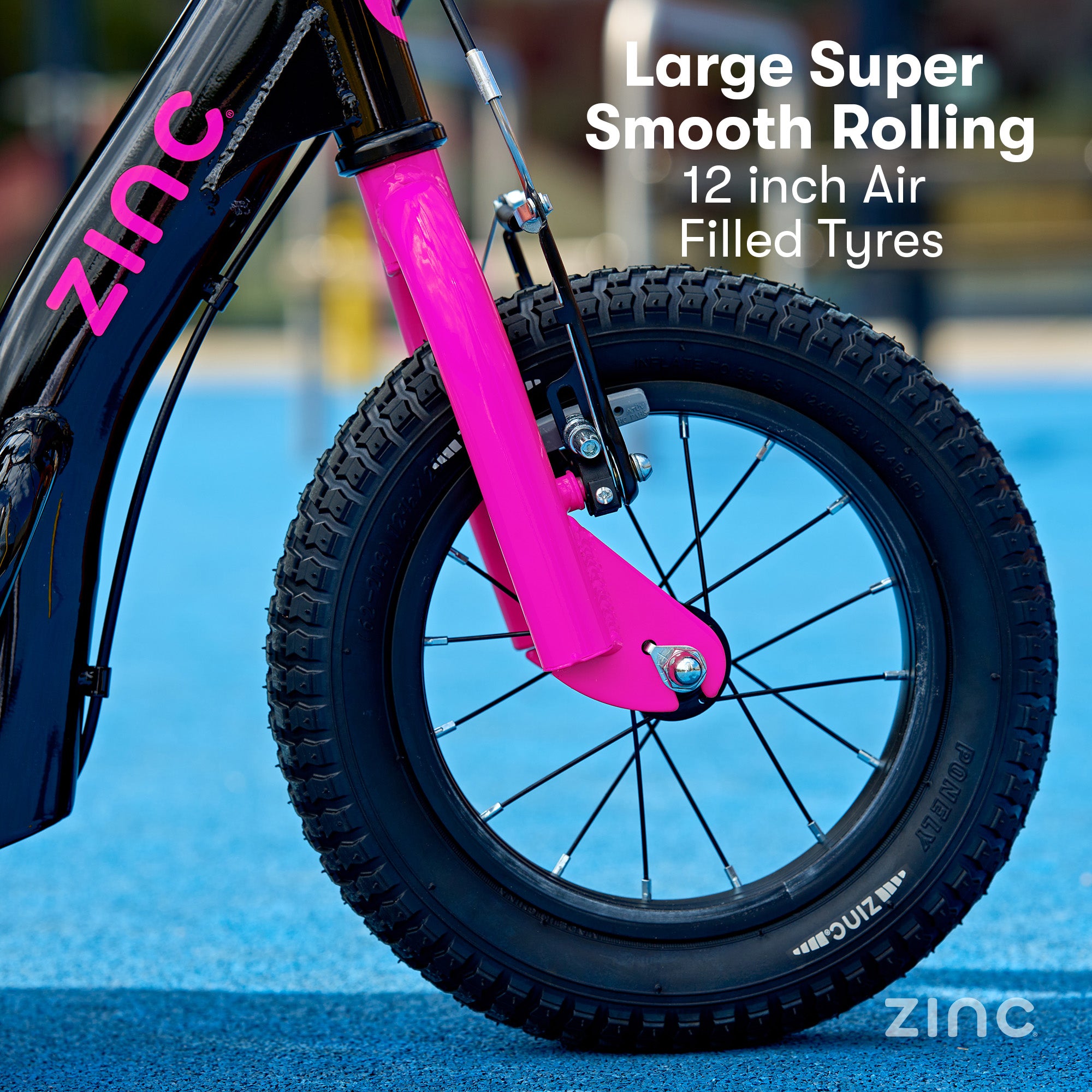 Close-up of a bicycle wheel with pink suspension fork on a blue surface, featuring 'Zinc' branding.