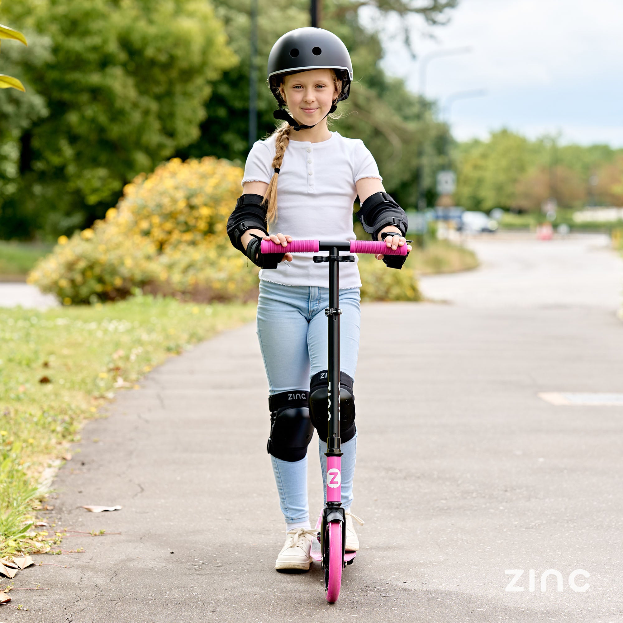 Cruise big wheeled scooter being ridden by girl in full protective gear