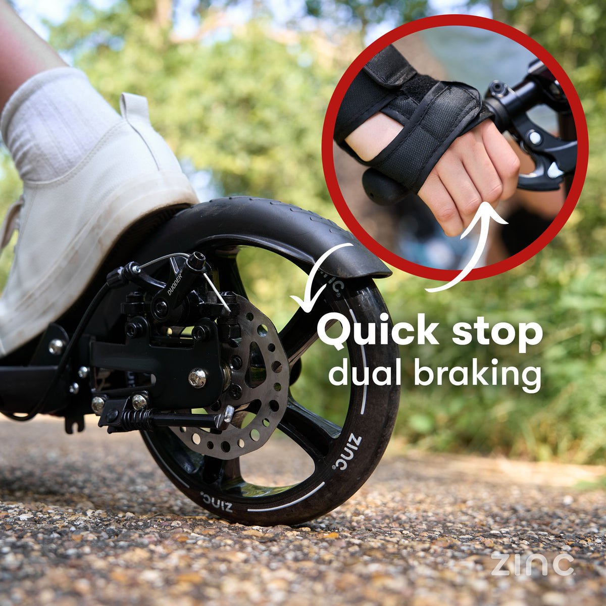 Close-up of a black wheel with a disc brake and a hand wearing a black quick-strap glove, with text reading 'Quick stop dual braking' and a circular inset showing the hand. The background is blurred outdoor pavement and greenery.