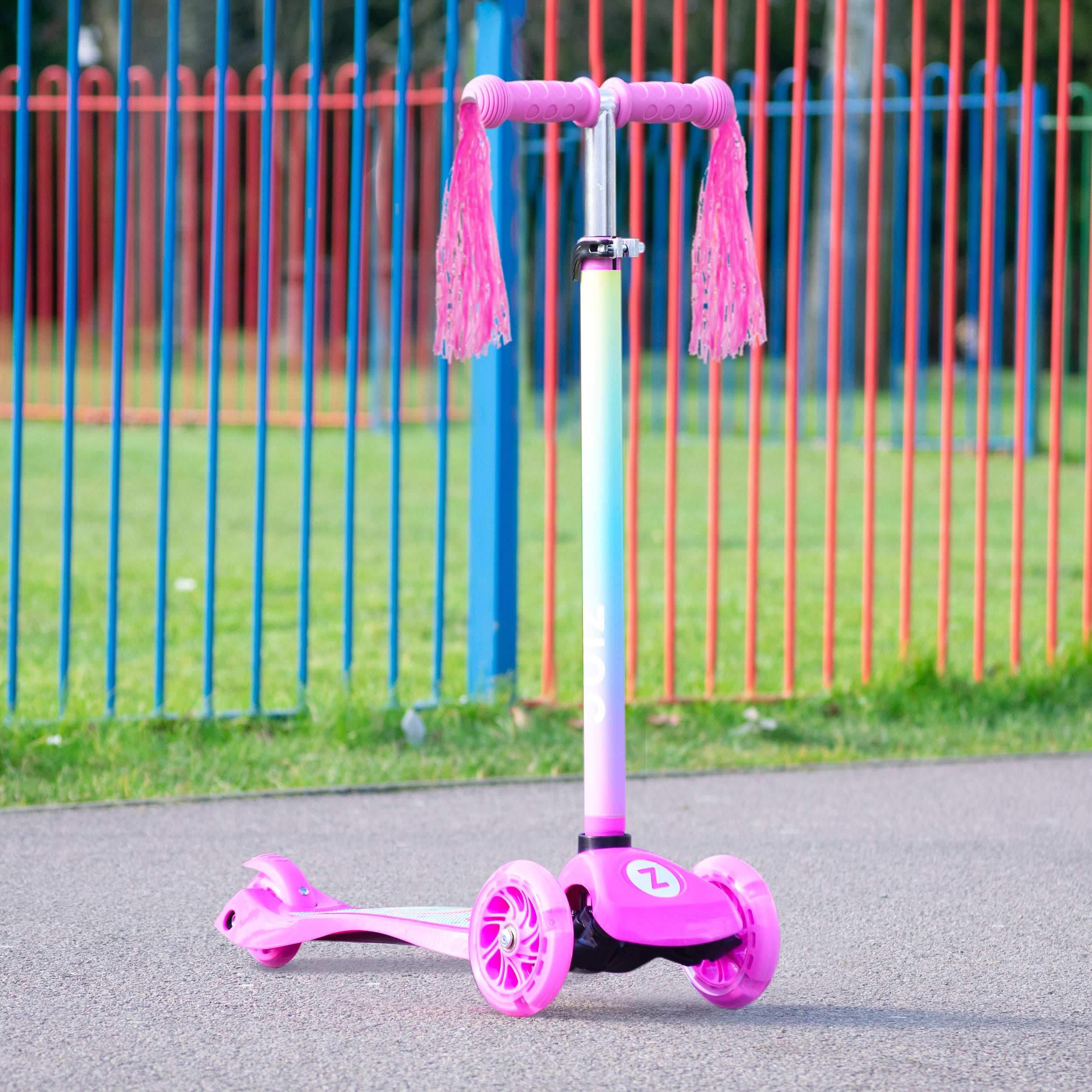 Zinc Three Wheeled Explorer Non Folding Scooter Unicorn in park setting with green grass and trees, showcasing outdoor play and light-up wheels