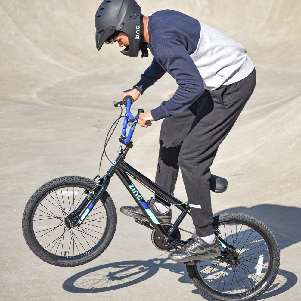Boy performing BMX tricks at skate park on ZINC Switch bike