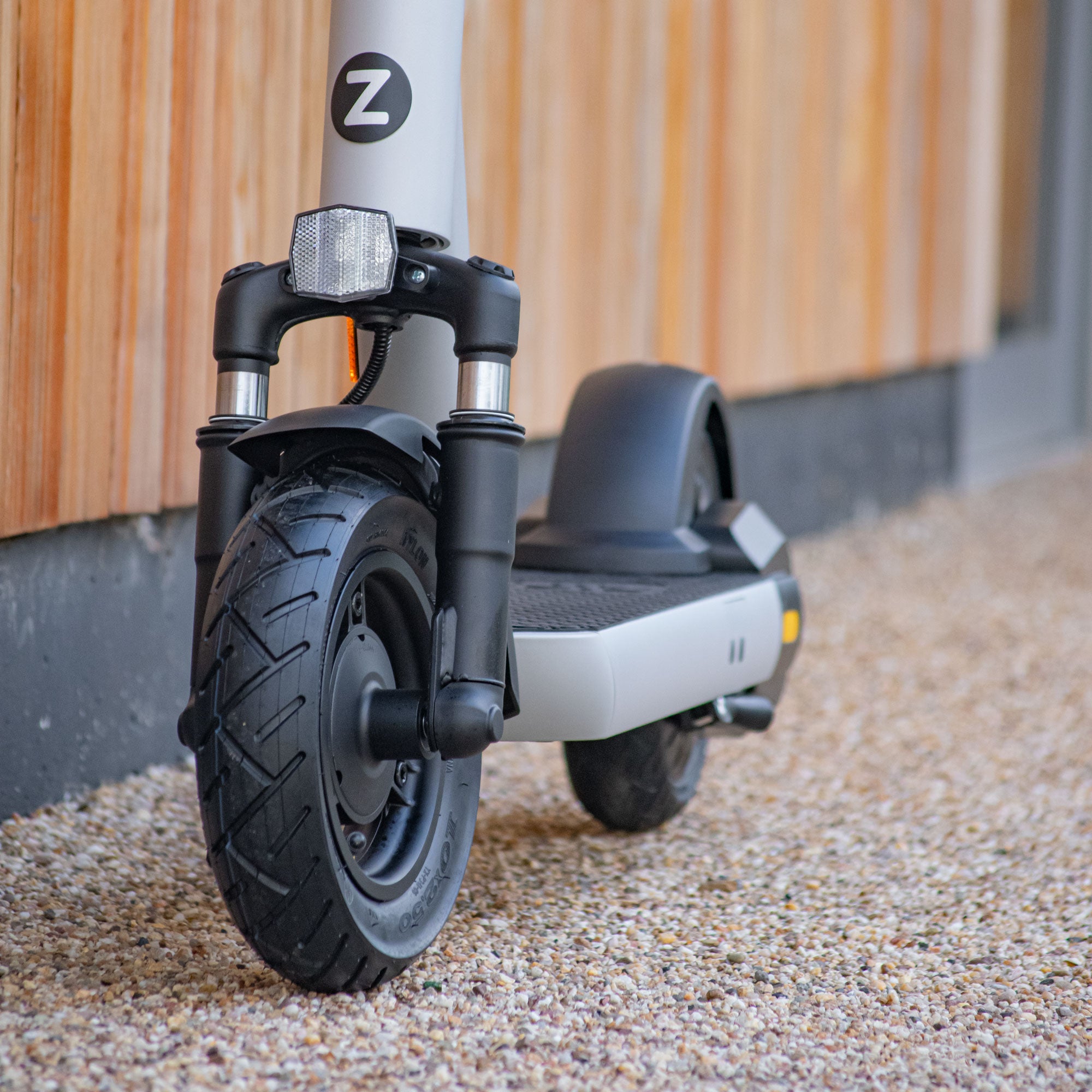 Electric scooter showing thumb throttle, LED display screen, and front/rear brake levers for safe control